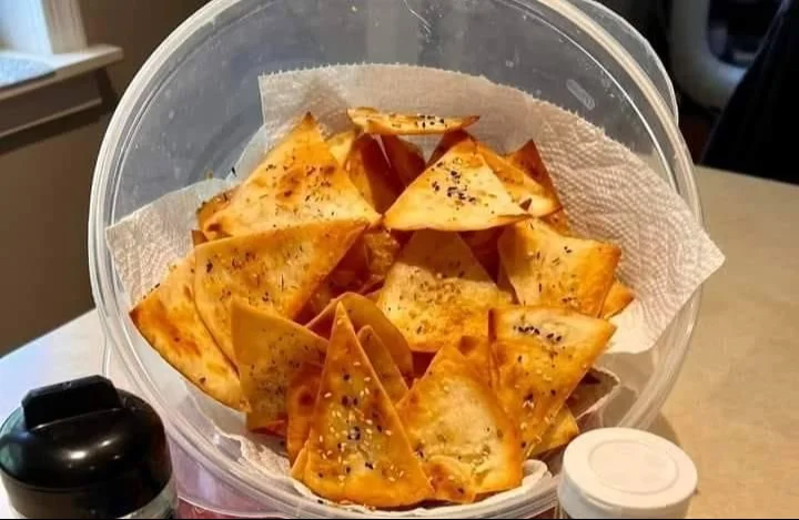 Baked tortilla chips served in a bowl with salsa on the side