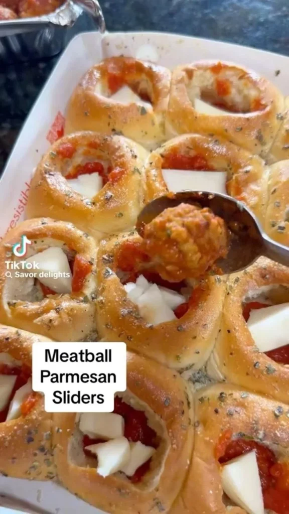 Delicious Meatball Parmesan Sliders topped with melted cheese and marinara sauce