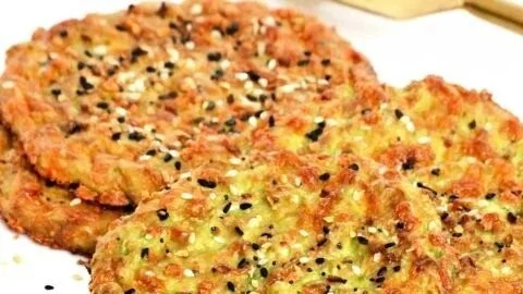 Slices of 3-ingredient avocado bread on a wooden board, garnished with herbs.