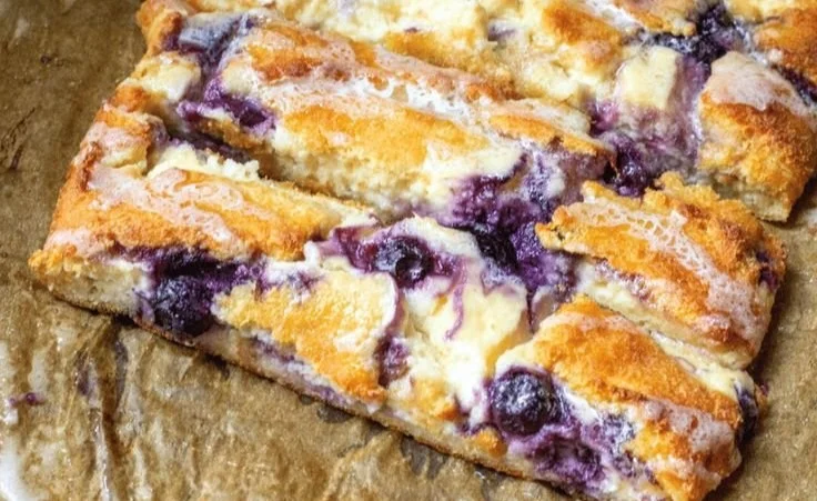 Braided blueberry cream cheese danish on a plate with fresh blueberries