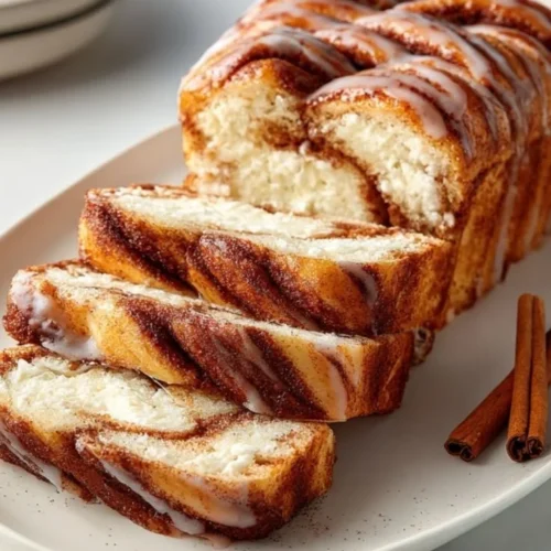 Deliciously fluffy cinnamon roll cottage cheese loaf sliced and served on a plate