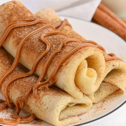 Delicious Cinnamon Roll Protein Crepes topped with icing and cinnamon powder