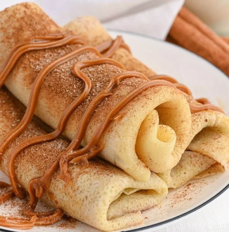 Delicious Cinnamon Roll Protein Crepes topped with icing and cinnamon powder