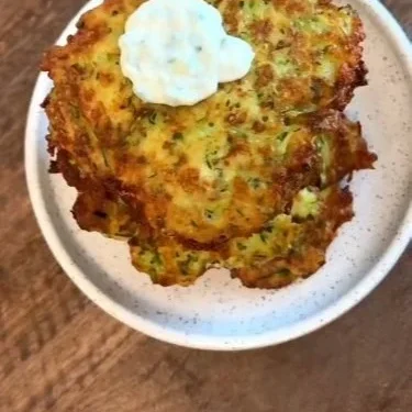 Crispy Zucchini Pancake 2 Delicious crispy zucchini pancake served on a plate garnished with herbs