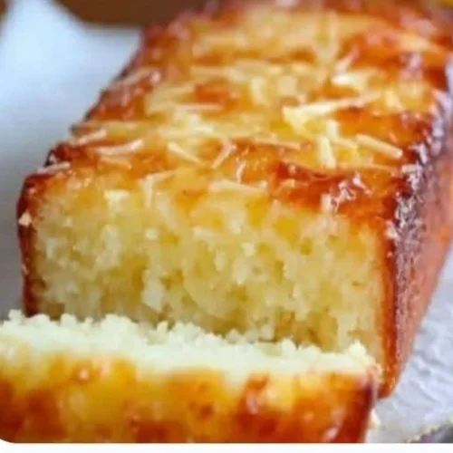 Delicious lemon yogurt cake served with fresh berries on a wooden table.