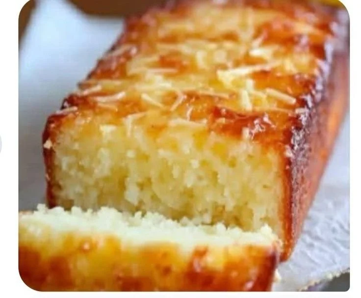 Delicious lemon yogurt cake served with fresh berries on a wooden table.