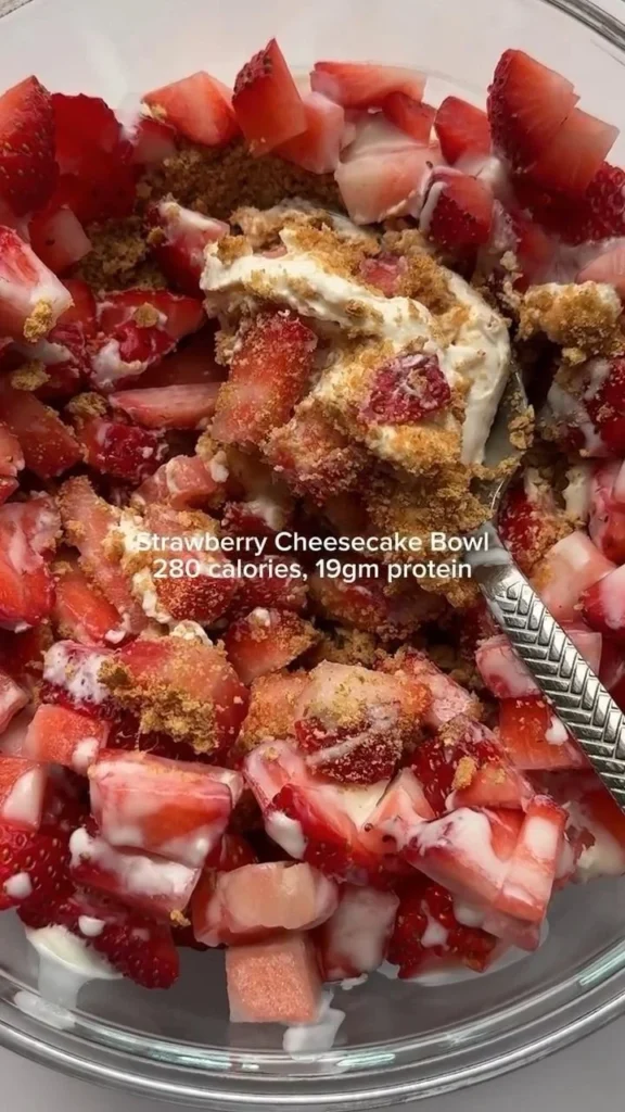 Delicious strawberry cheesecake bowl topped with fresh strawberries and whipped cream.