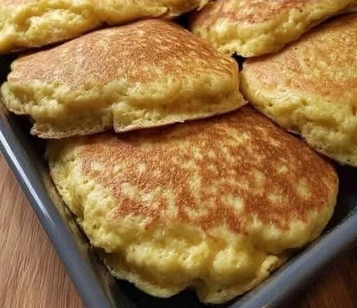 Plate of sweet Mexican pancakes drizzled with syrup and topped with fruit