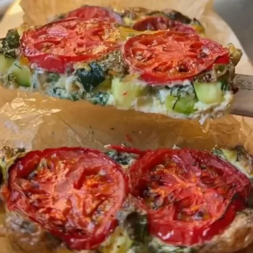 Zucchini and Tomato Frittata 2 Zucchini and tomato frittata served on a plate, showcasing a colorful dish.